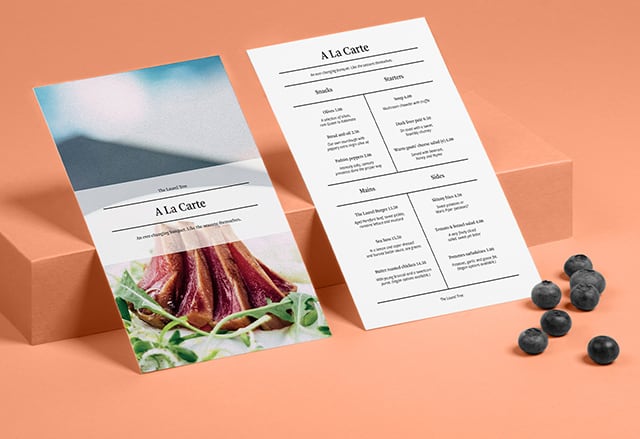 2 minimalist menu designs on high-quality paper, 1 seen from the front and 1 from the back, both on a coral background