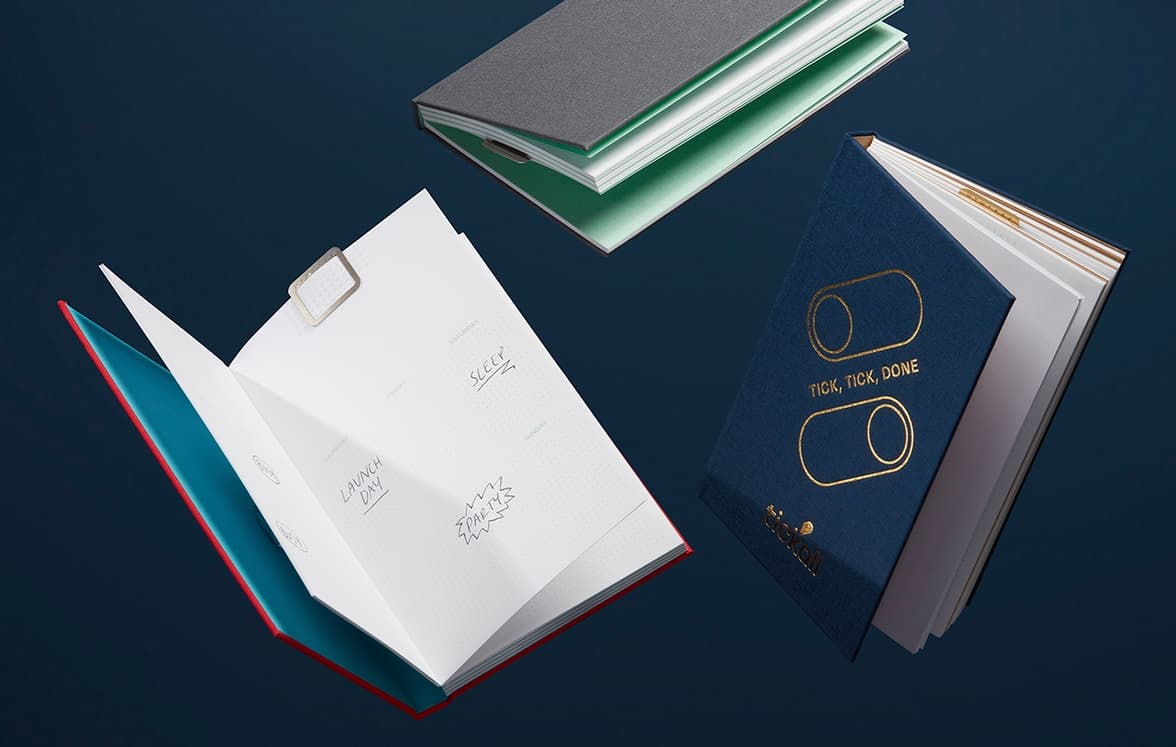A collection of three perpetual planners, varying in color and customization.