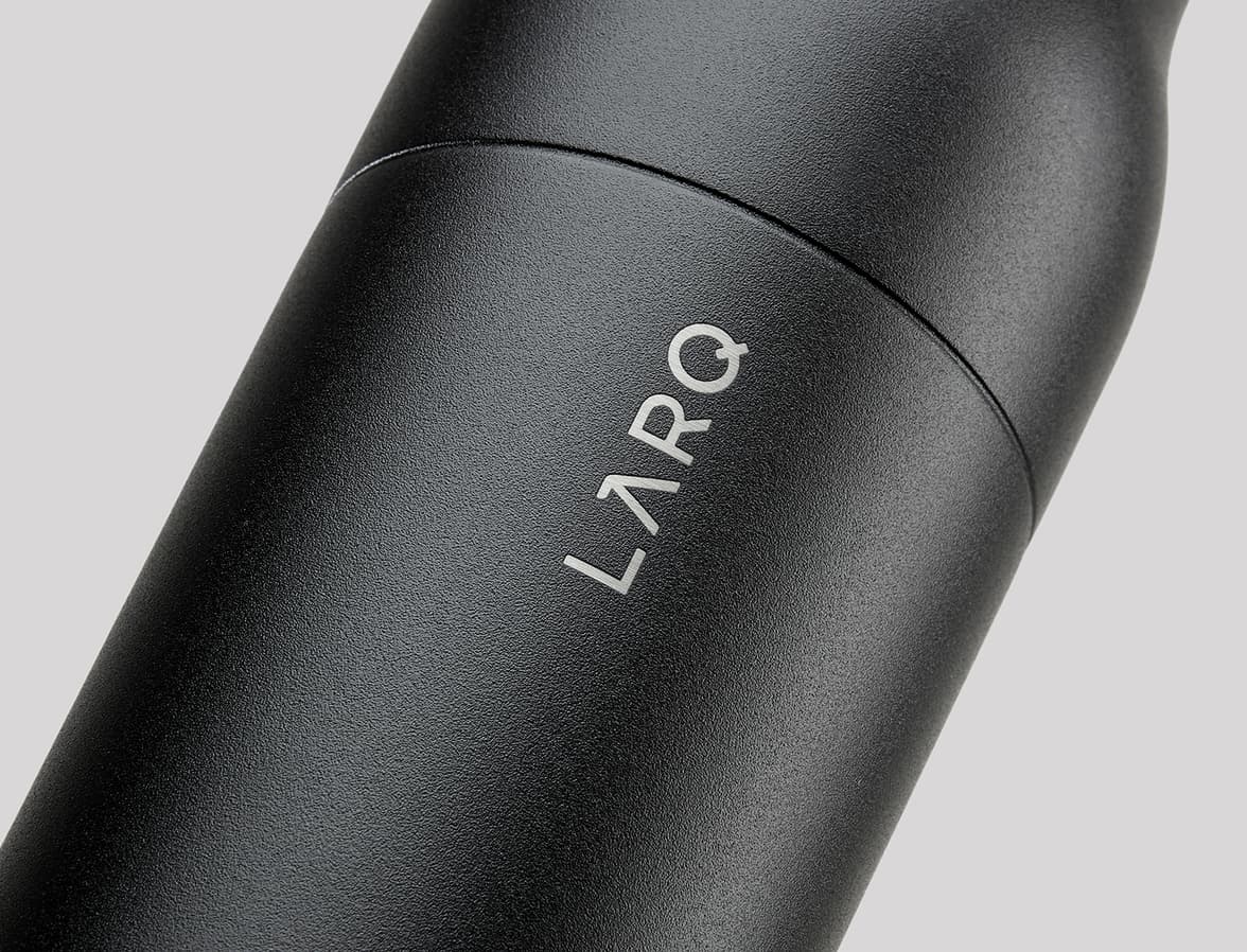 A close-up of a matte black bottle. The word LARQ is debossed on the bottle.